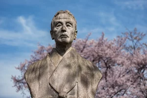 bust of man with cherry blossoms behind