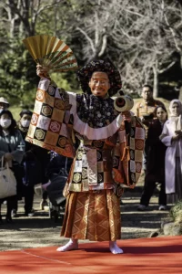 man in kimono and fan raised